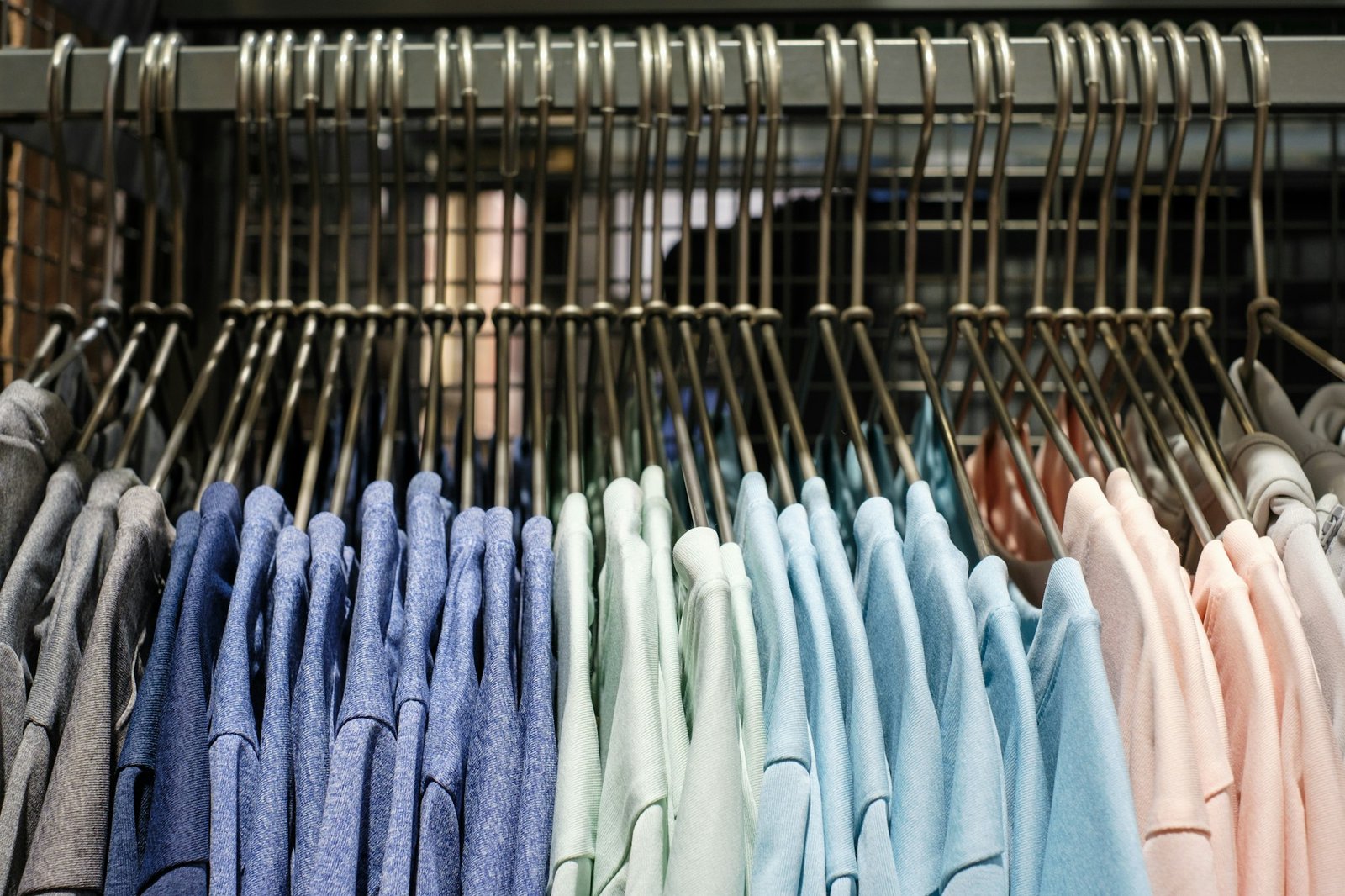 Multicolored t-shirt hang on hangers close-up side view.